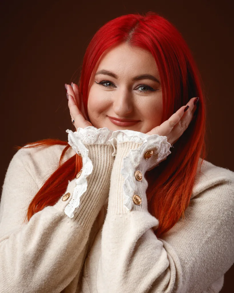 Smiling woman with red hair and cream jumper