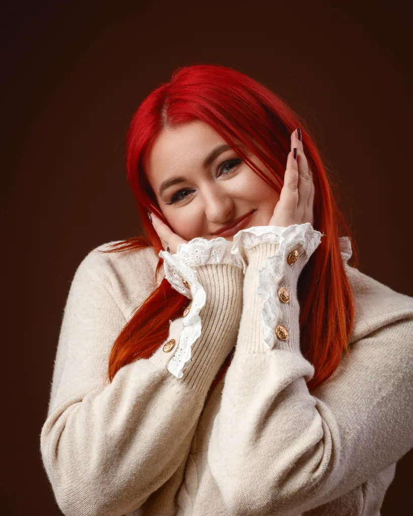 Smiling woman with red hair in cosy beige sweater