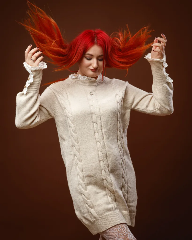 Woman with red hair wearing cream knitted sweater