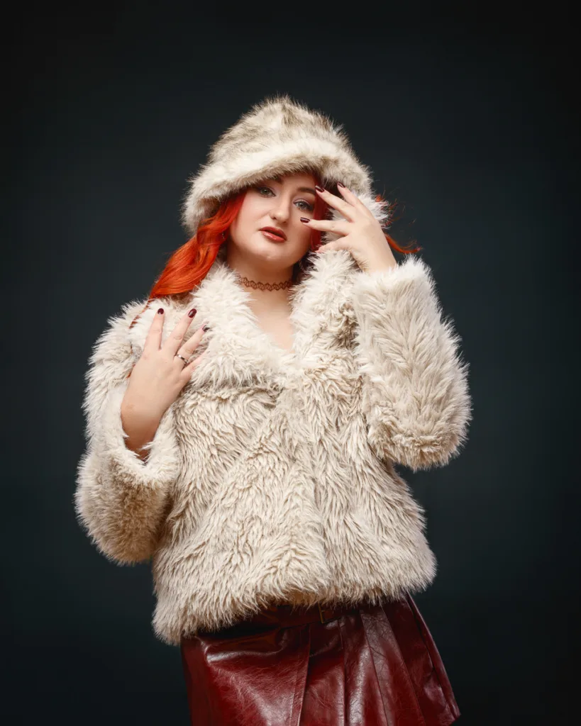Woman in faux fur coat and leather skirt posing
