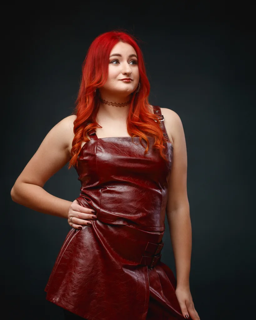 Woman in red leather dress posing confidently