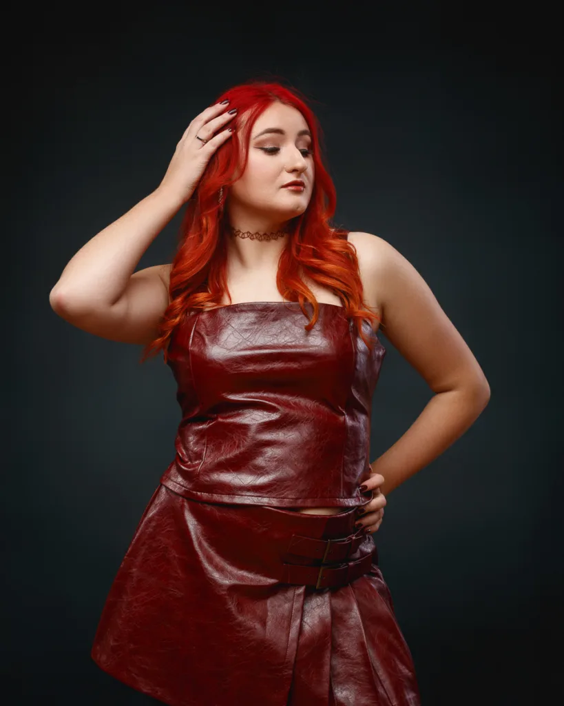 Woman in red leather outfit posing confidently