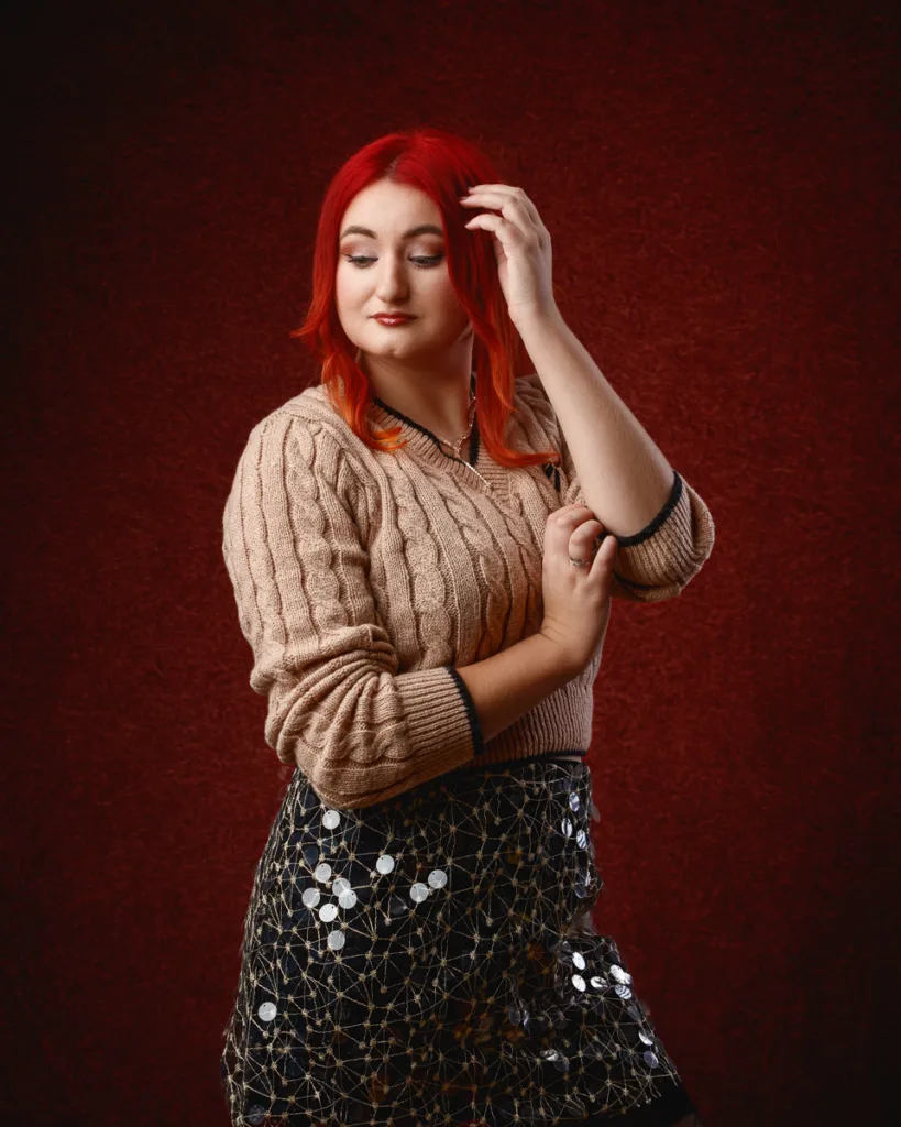 Person posing against dark red background