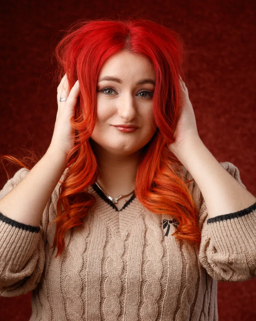 Smiling woman with bright red hair posing confidently