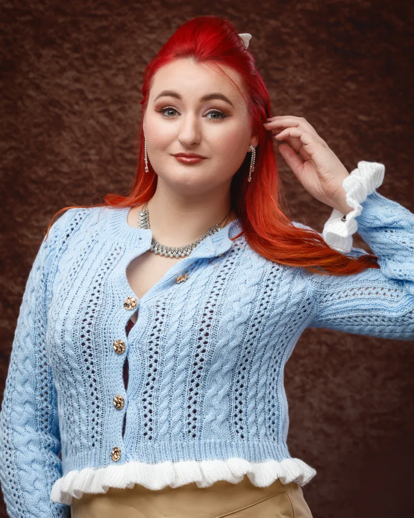 Woman in blue knitted cardigan posing confidently