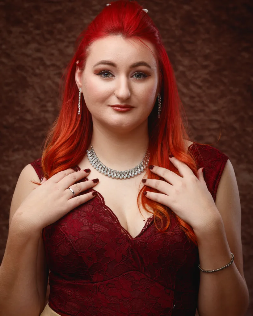 Woman in red dress with jewellery posing confidently