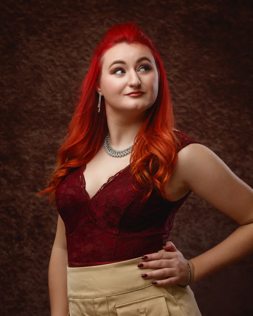Woman with red hair wearing burgundy lace top