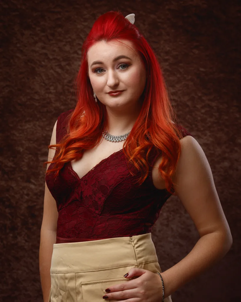 Woman with red hair wearing burgundy lace top