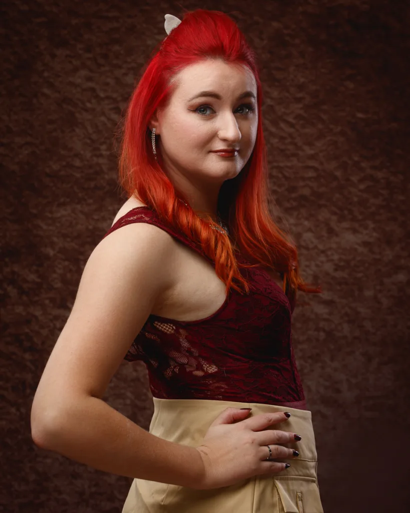 Woman with red hair posing confidently indoors