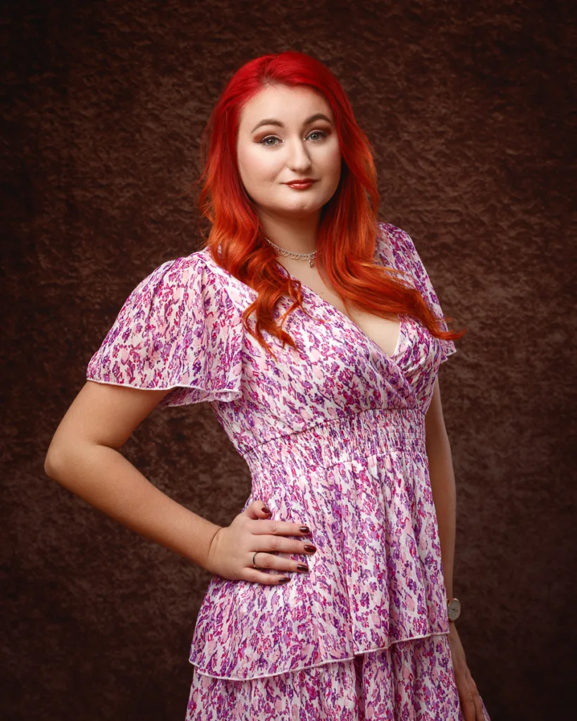 Woman with red hair wearing patterned pink dress
