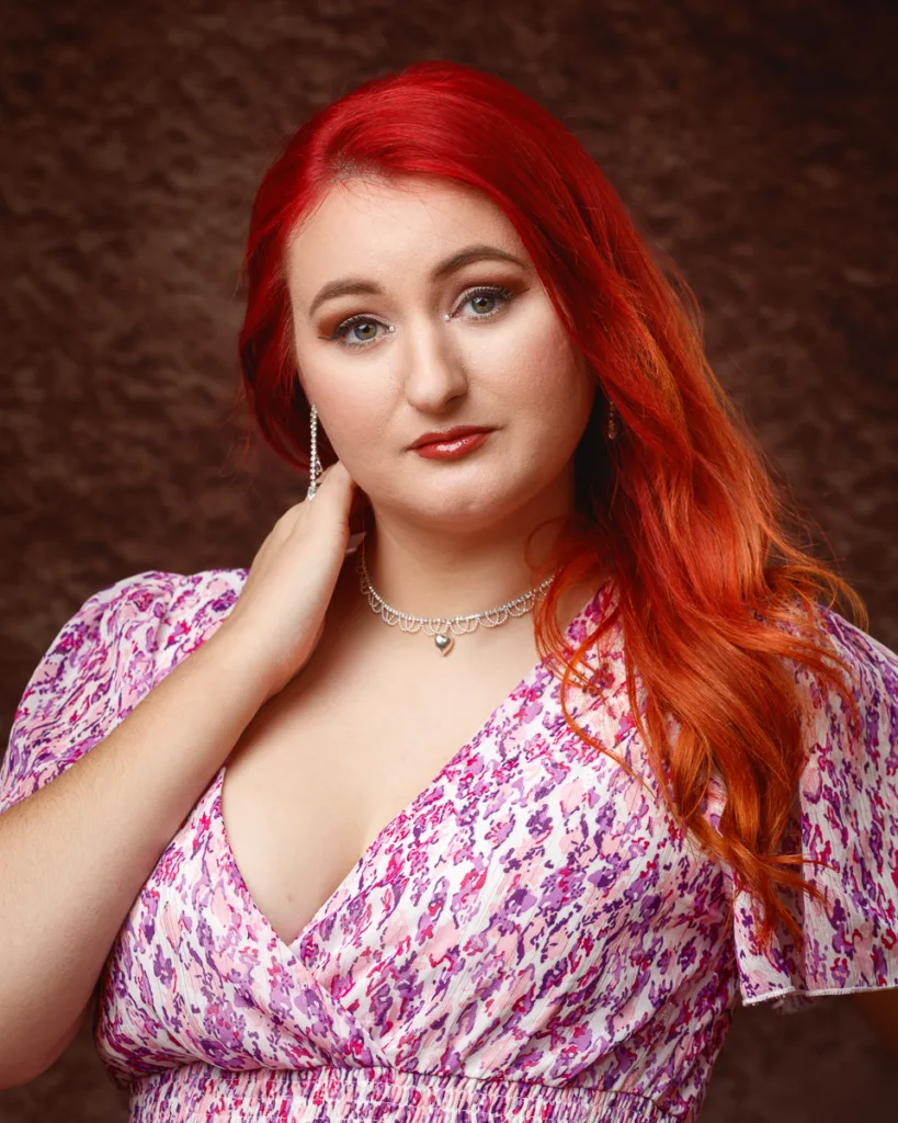 Woman with red hair wearing pink patterned dress