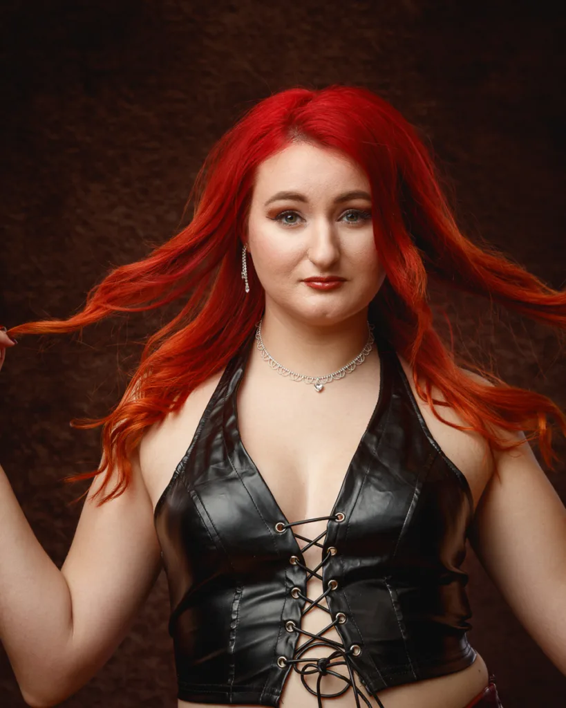 Woman with red hair wearing black leather top