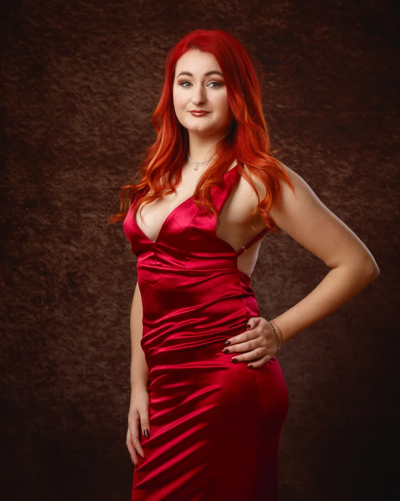 Woman wearing elegant red satin dress posing confidently