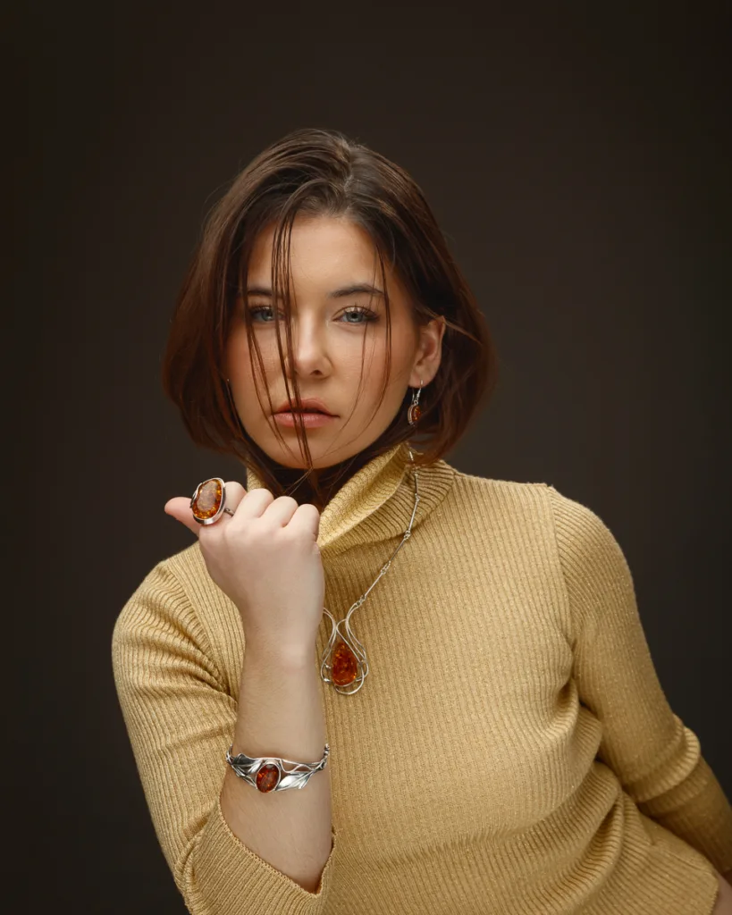 Woman wearing amber jewellery and beige jumper