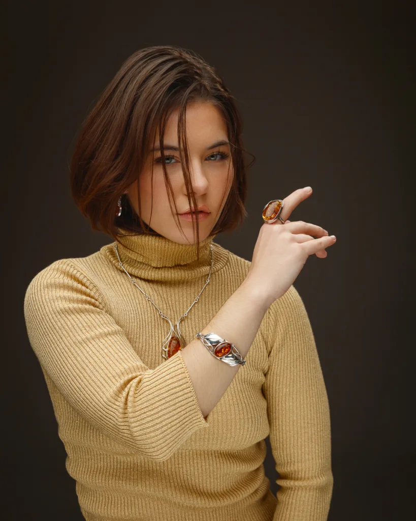 Woman wearing amber jewellery and turtleneck.