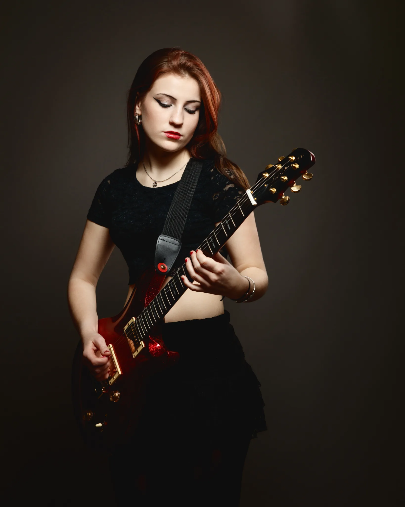 Woman playing electric guitar on stage.
