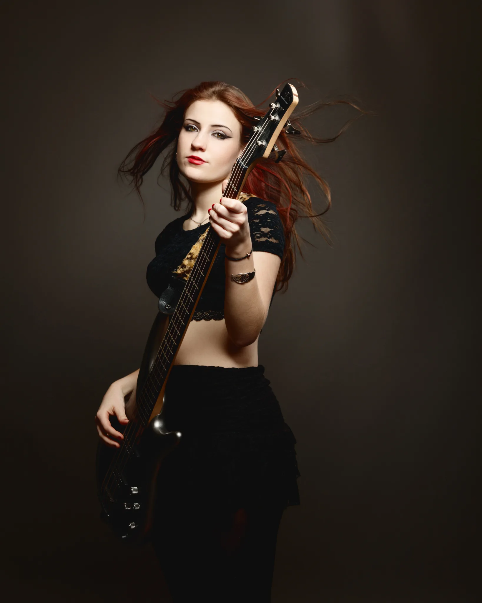 Woman playing electric guitar confidently.