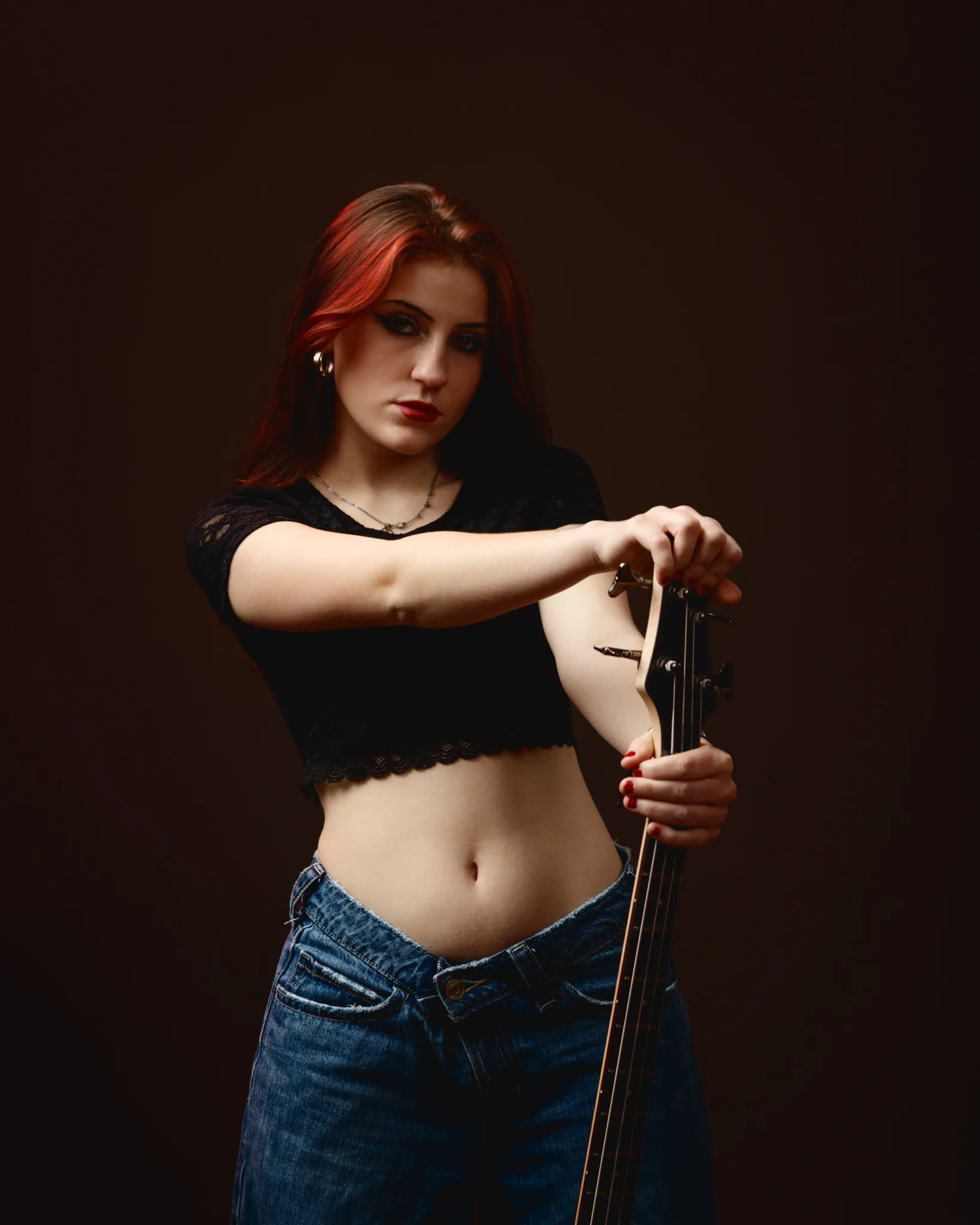Woman in jeans holding a guitar
